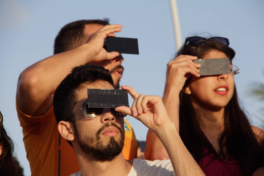 Pessoas observam o eclipse parcial do sol, no Parque da Cidade, em Natal (RN) na tarde desta segunda-feira (21)