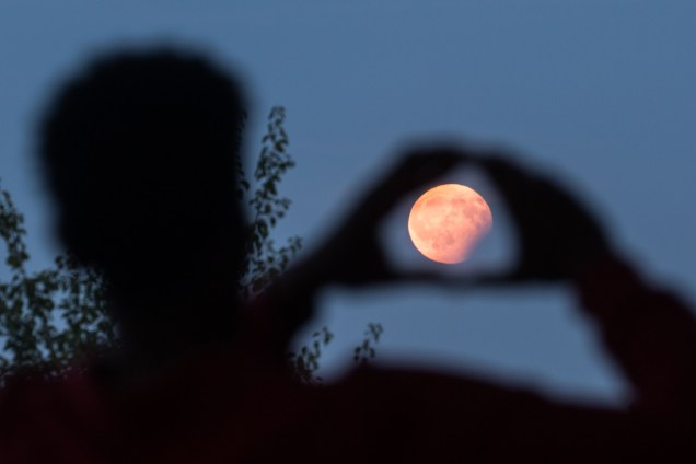 Homem é fotografado encaixando a lua em sua mão durante o eclipse parcial em Frankfurt, na Alemanha - 07/08/2017
