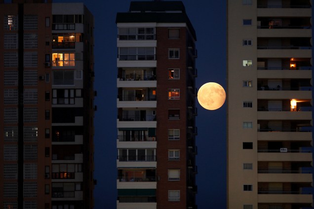 O nascer da lua é fotografado entre os prédios da cidade de Málaga, na Espanha, na noite do Eclipse parcial lunar - 07/08/2017