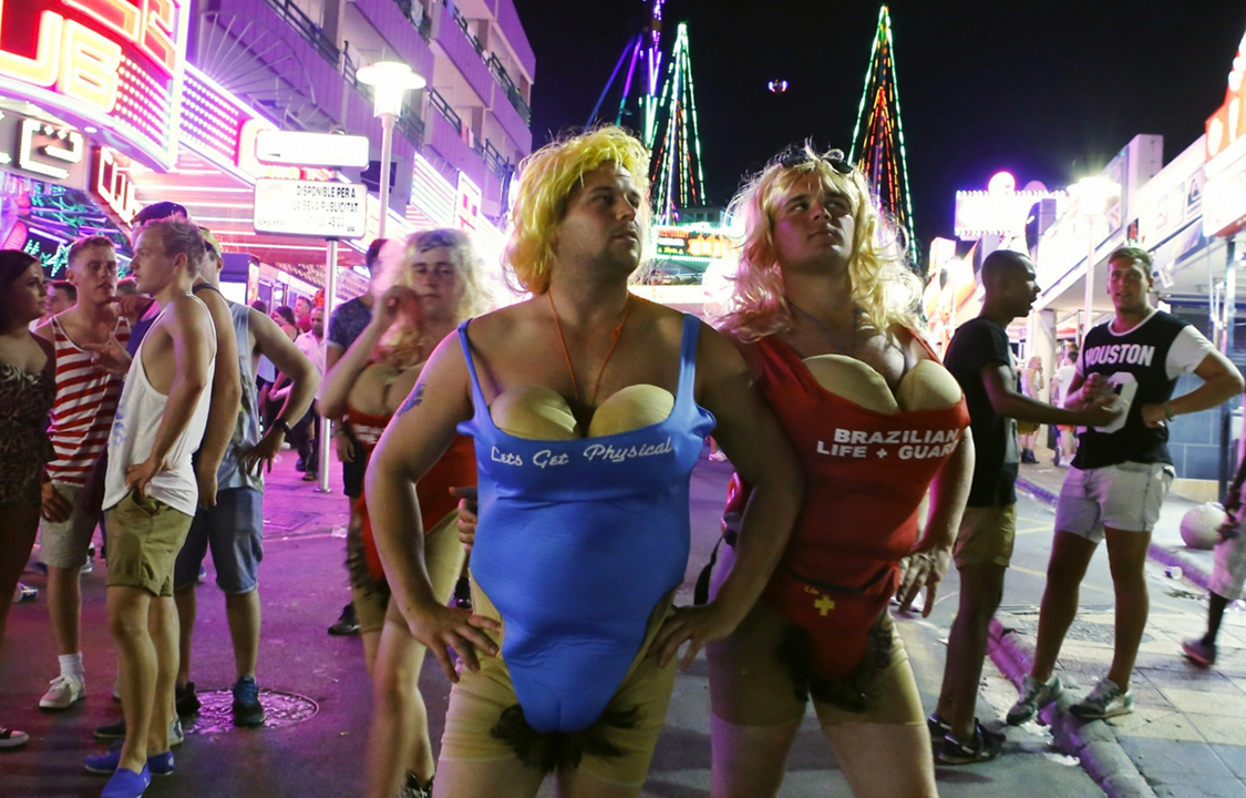 Turistas se fantasiam e posam para foto em movimentada avenida na ilha de Maiorca, na Espanha