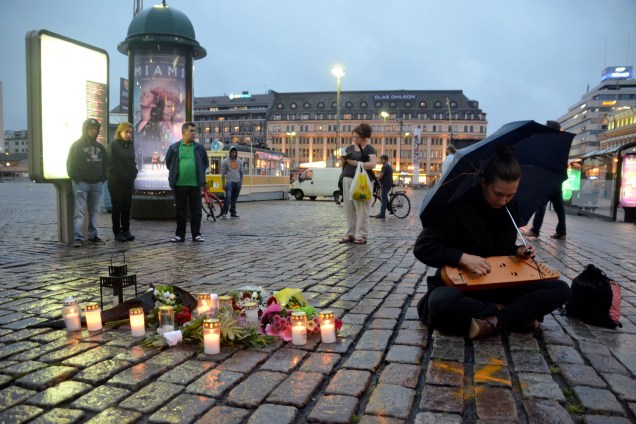 Mulher seu toca seu kântele, um instrumento tradicional da Finlândia, na Praça do Mercado, onde várias pessoas foram esfaqueadas durante um atentado, em Turku, na Finlândia
