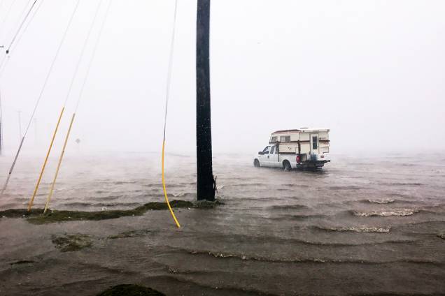 Carro passa por uma inundação na cidade de Corpus Christi, antes da chegada do furacão Harvey, no Texas