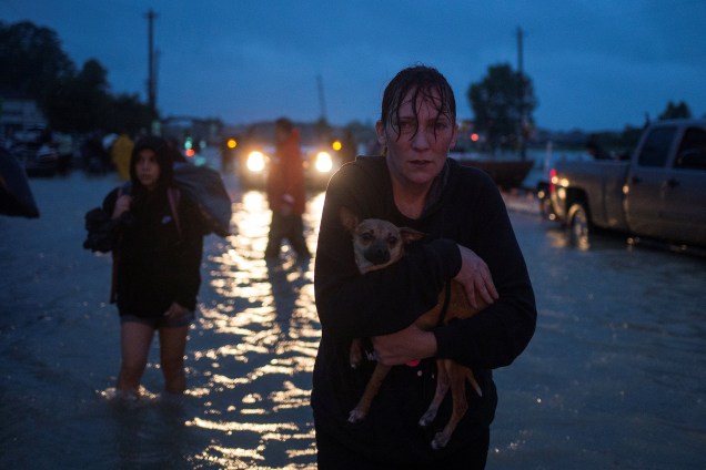 Uma mulher leva seu cachorro no colo durante a evacuação de casas em Houston, após a tempestade do furacão Harvey, no estado americano do Texas - 28/08/2017
