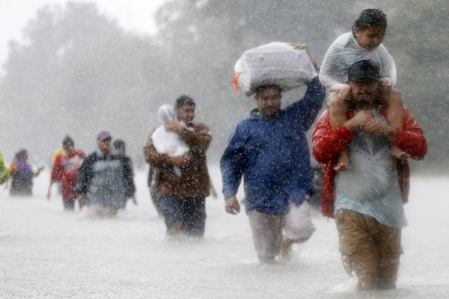 Moradores atravessam as águas da tempestade causado pelo furacão Harvey, em Beaumont Place, Houston, Texas, EUA - 28/08/2017