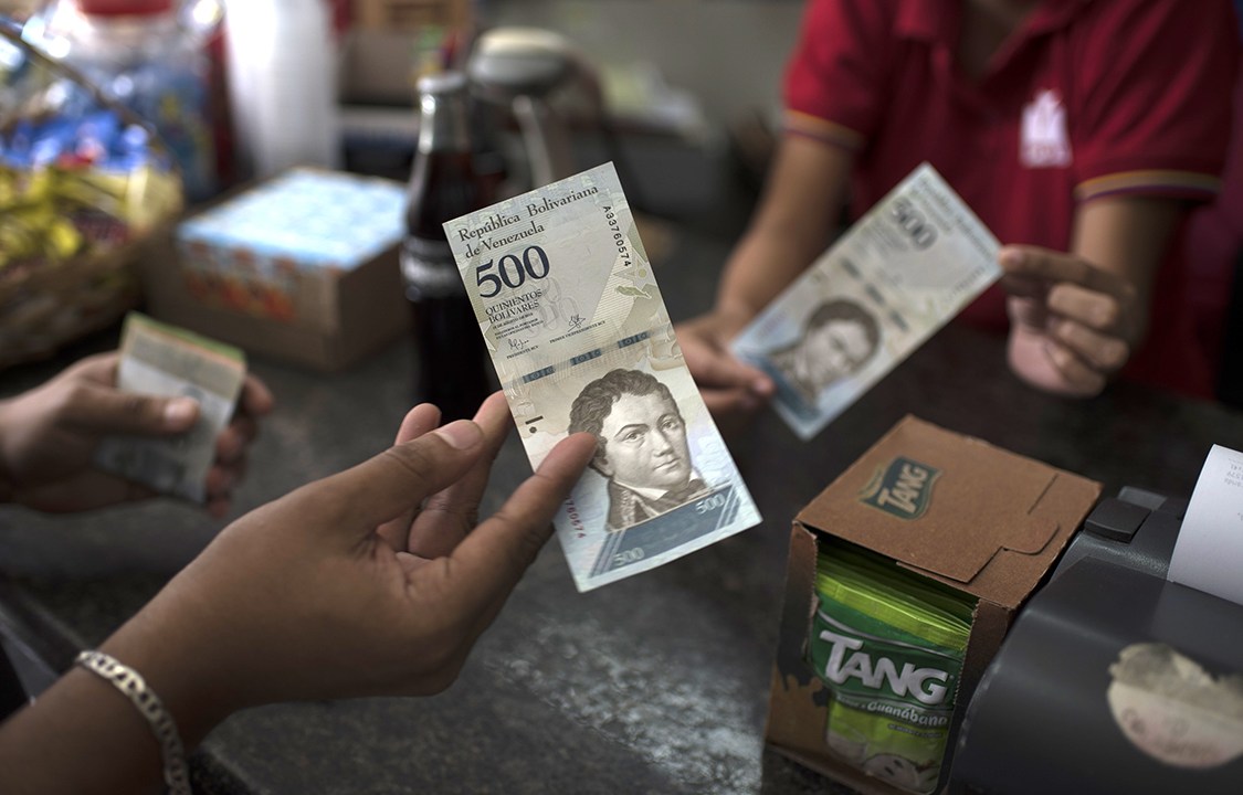 Consumidores entregam notas de 500 bolívares venezuelanos