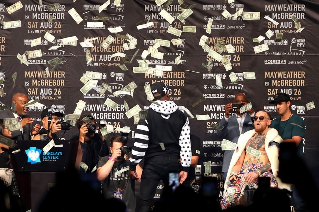 Floyd Mayweather Jr. joga dinheiro em direção a Conor McGregor durante coletiva de imprensa em Nova York - 13/07/2017