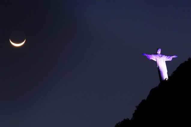 Cristo Redentor com a lua crescente visto de Botafogo, zona sul do Rio de Janeiro (RJ), neste início de noite de quinta-feira (24)