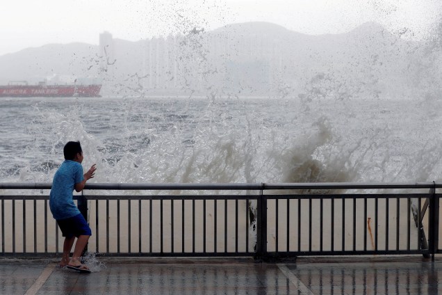 Grandes ondas provenientes do tufão Hato chocam contra a costa de Hong Kong, na China, e assustam um garoto que passava por ali - 23/08/2017
