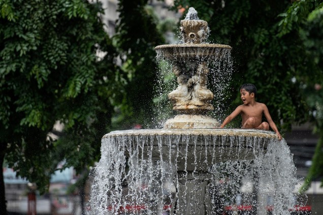 Garoto brinca em uma fonte de água publica na cidade de Manila, capital das Filipinas - 03/08/2017 Garoto brinca em uma fonte de água publica na cidade de Manila, capital das Filipinas - 03/08/2017