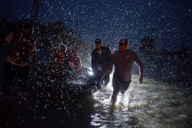 Voluntários ajudam a empurrar um barco com moradores retirados de suas residências durante inundação causada pela tempestade tropical Harvey em Houston, no Texas - 28/08/2017