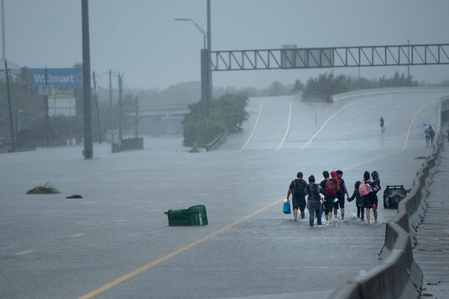 Moradores atravessam um viaduto com seus pertences após evacuarem suas casas em decorrências das inundações provocadas pela passagem do furacão Harvey em Houston, no estado americano do Texas - 27/08/2017