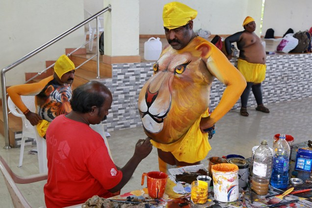 Um artista tem seu corpo pintado para parecer um leão antes de participar das festividades que marcam o início do festival anual de colheita de Onam, em Kochi, na Índia - 25/08/2017