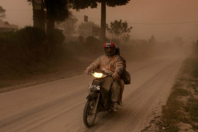 Homem monta em sua moto após a erupção do vulcão Mount Sinabung, em Beganding, na província de Sumatra Setentrional, Indonésia - 02/08/2017