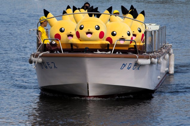 Artistas vestidos como Pikachu, personagem dos jogos e da série Pokémon, viajam em um barco durante o evento Pikachu Outbreak, organizado pelo The Pokemon Co. em Yokohama, na província de Kanagawa, Japão