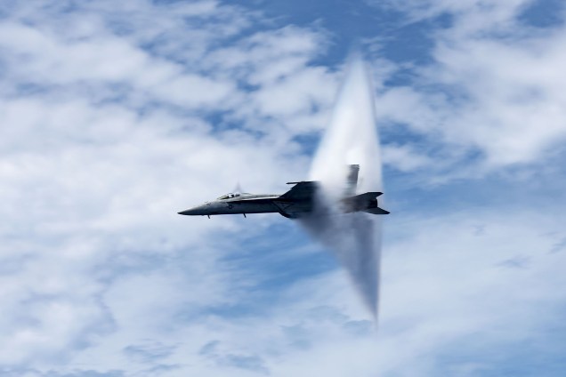 Imagem divulgada pela Marinha dos Estados Unidos mostra o caça Super Hornet F/A-18E no momento em que a aeronave quebra a barreira de som acima do porta-aviões USS George H.W. Bush durante demonstração de poder aéreo em local não revelado no Oceano Atlântico - 20/08/2017