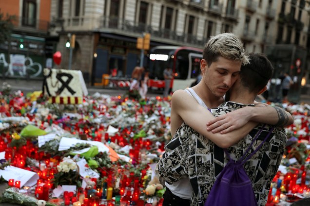 Homens se abraçam em frente a um memorial improvisado em homenagem às vítimas do atropelamento em Las Ramblas em Barcelona, na Espanha - 21/08/2017