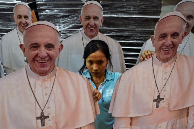 Mulher é fotografada em meio a imagens em tamanho real do papa Francisco em um centro de impressão em Cáli, na Colômbia. O líder dos católicos realizará uma visita especial de quatro dias à Colômbia, entre 6 e 11 de setembro - 15/08/2017