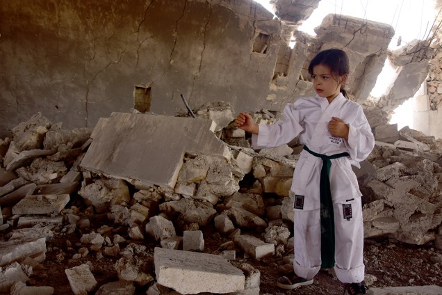 Garota síria treina exercícios de karatê em meio a destroços na cidade de Aleppo, na Síria. Com pais treinadores, o sonho de Nur Setut, de 6 anos, é ser campeã de karatê - 09/08/2017