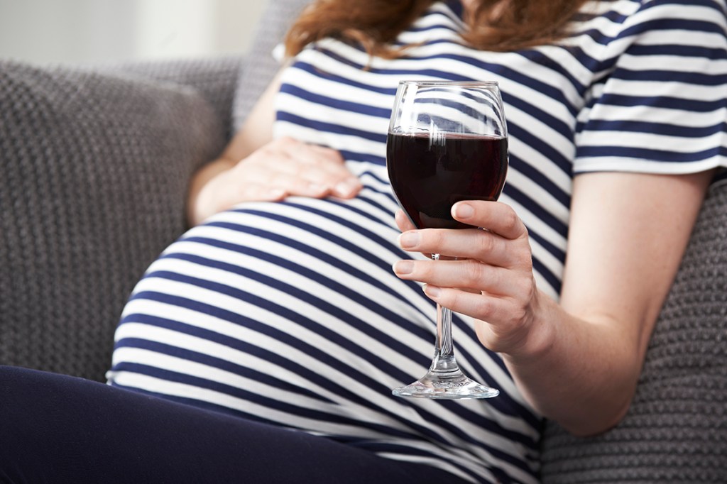 Mulher grávida bebendo vinho