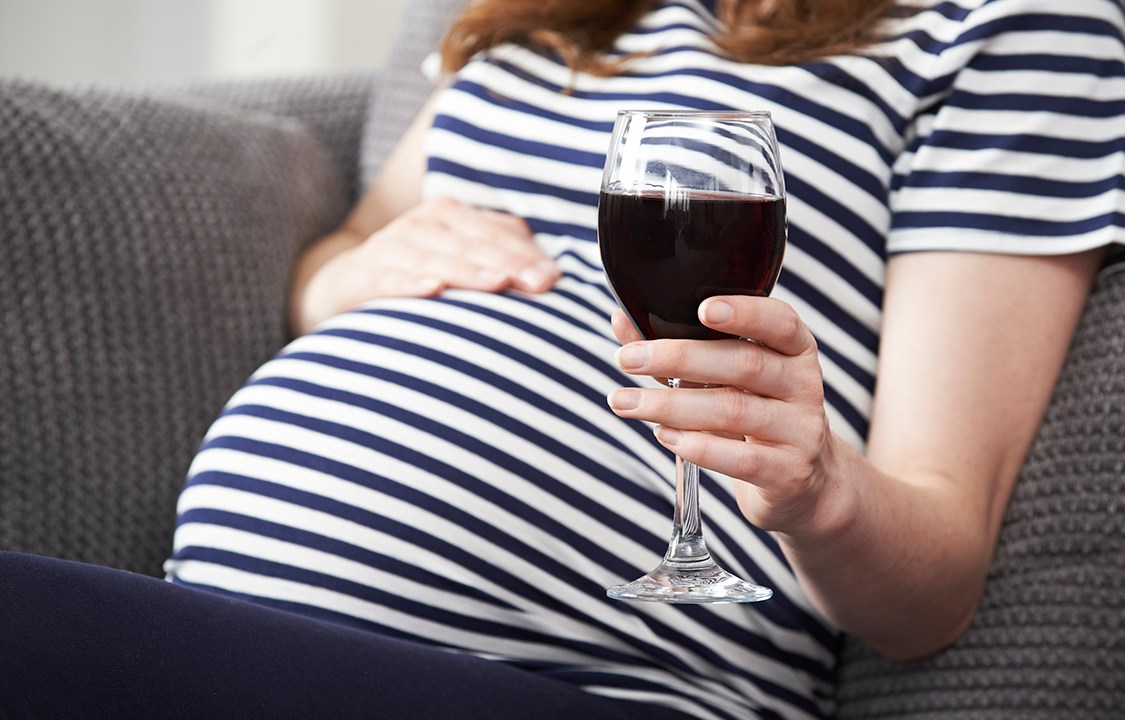 Mulher grávida bebendo vinho
