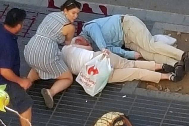 Mulher acode vítimas de atropelamento terrorista em La Rambla, Barcelona, na Espanha
