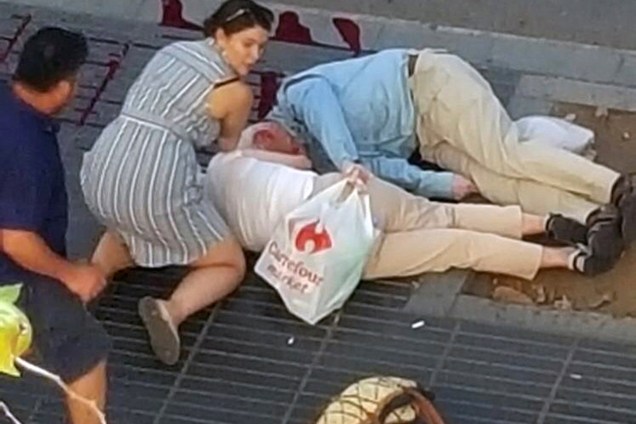 Mulher acode vítimas de atropelamento terrorista em La Rambla, Barcelona, na Espanha