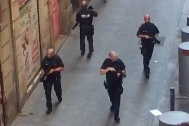 Policiais armados patrulham uma rua vazia, depois de uma van ter atropelado pedestres nos arredores da avenida Las Ramblas, no centro de Barcelona, na Espanha - 17/08/2017