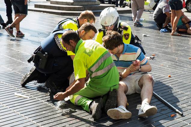 Equipe de resgate ajuda uma mulher ferida depois de um atropelamento nos arredores da avenida Las Ramblas, no centro de Barcelona, na Espanha - 16/08/2017