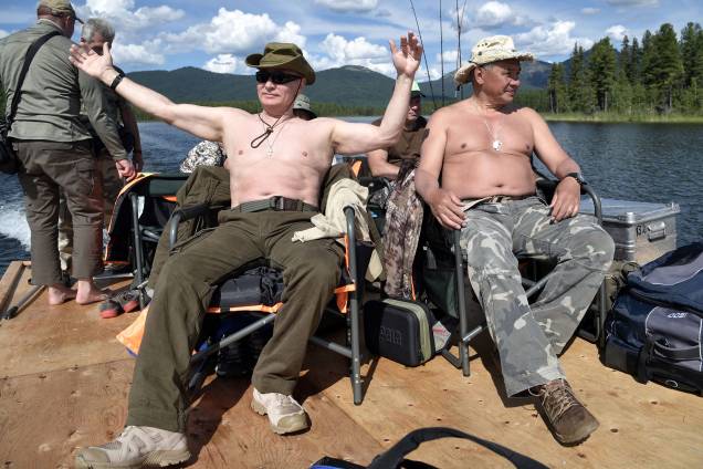 O presidente russo Vladimir Putin e o ministro da Defesa, Sergei Shoigu, descansam depois de pescar durante viagem na república de Tyva O presidente russo Vladimir Putin e o ministro da Defesa, Sergei Shoigu, descansam depois de pescar durante viagem na república de Tyva