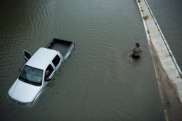 Morador abandona o carro após evacuar sua casa em decorrências das inundações provocadas pela passagem do furacão Harvey em Houston, no estado americano do Texas - 28/08/2017