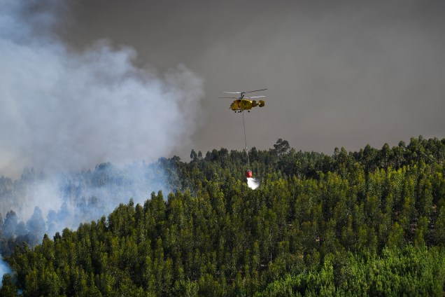 Helicóptero despeja água para conter as chamas do incêndio florestal em Abrantes, Portugal. Cerca de 650 bombeiros apoiados por nove aeronaves e mais de 200 veículos, estavam no local da maior ocorrência