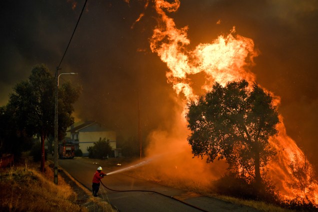 Bombeiro tenta extinguir o fogo do incêndio florestal que atingiu a vila de Pucarica, na cidade de Abrantes, Portugal