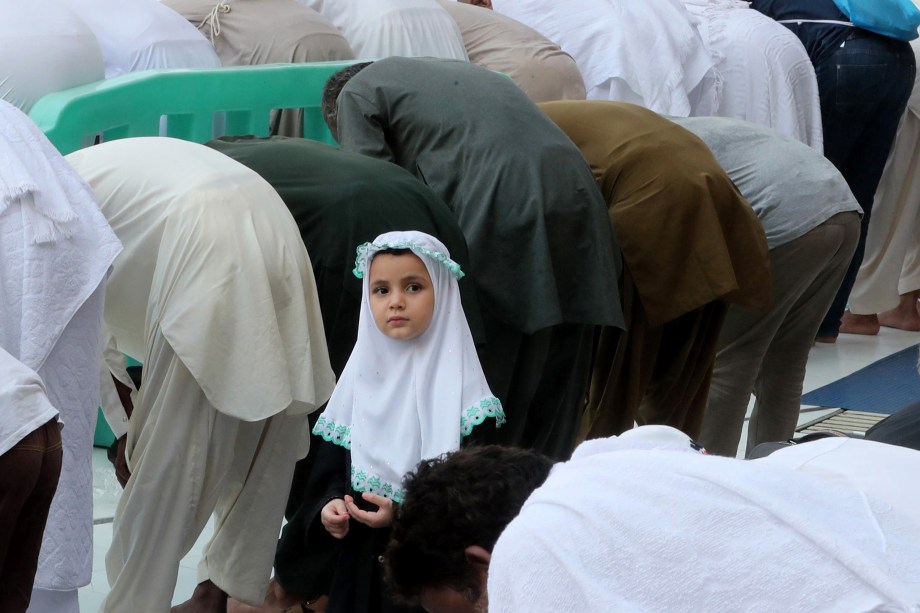 Criança observa a oração dos peregrinos muçulmanos na Grande Mesquita na cidade saudita de Meca, na véspera do início da peregrinação anual do Hajj - 29/08/2017