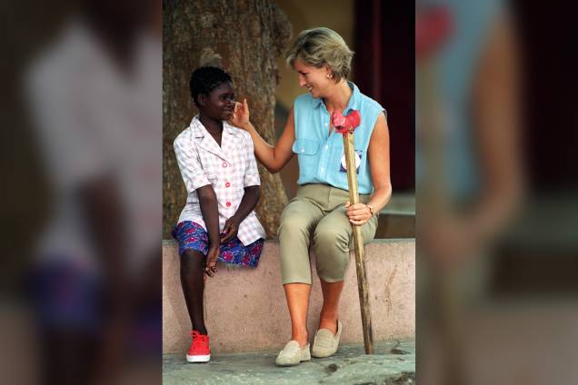 Princesa Diana conversa com a menina Sandra Thijika durante visita a uma oficina ortopédica em Luanda, Angola em janeiro de 1997