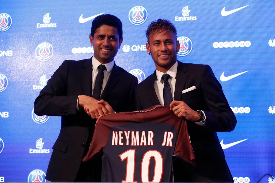 O presidente do PSG Nasser Al-Khelaifi posa para foto ao lado de Neymar durante a coletiva de imprensa, segurando a camisa que o atacante irá usar