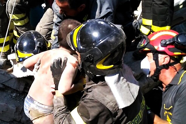 Bombeiros resgatam uma criança ferida após um terremoto na ilha de Ischia, ao largo da costa de Nápoles, na Itália - 22/08/2017