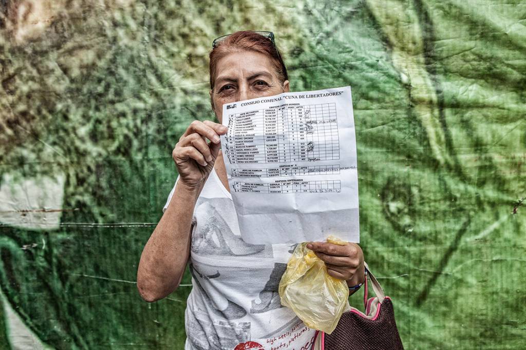 GUERRA ECONÔMICA? – Carmen Araujo mostra a lista dos moradores que recebem as cestas básicas: a escolha dos beneficiários é política