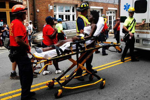 Equipes de resgate levam mulher ferida por um carro que avançou sobre multidão que protestava contra supremacista brancos