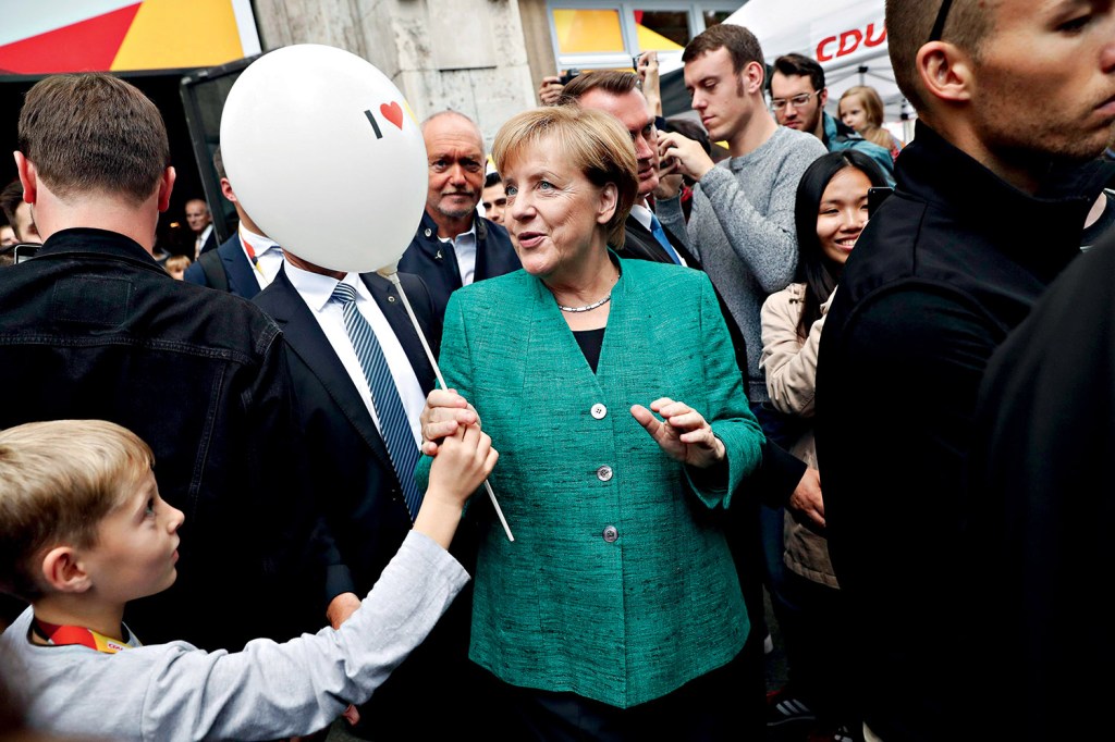 efephotos923818 - FT109. Berlin (Germany), 17/09/2017.- German Chancellor Angela Merkel receives a balloon from a child as she leaves an event in an interactive exhibition space of the Christian Democratic Union (CDU) party in Berlin, Germany, 17 September 2017. Others are not identified. Germany's political parties entered into the last week of campaigning before the general elections on 24 September 2017. Credito: FELIPE TRUEBA/EPA/EFE