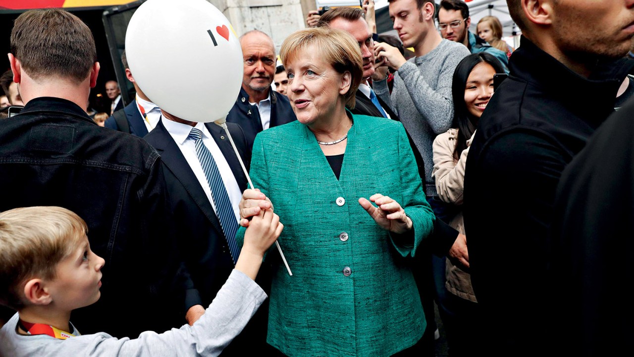 efephotos923818 - FT109. Berlin (Germany), 17/09/2017.- German Chancellor Angela Merkel receives a balloon from a child as she leaves an event in an interactive exhibition space of the Christian Democratic Union (CDU) party in Berlin, Germany, 17 September 2017. Others are not identified. Germany's political parties entered into the last week of campaigning before the general elections on 24 September 2017. Credito: FELIPE TRUEBA/EPA/EFE