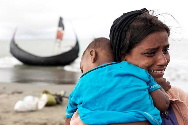 Refugiada rohingya chora com seu filho nos braços ao chegar em Bangladesh - 12/09/2017