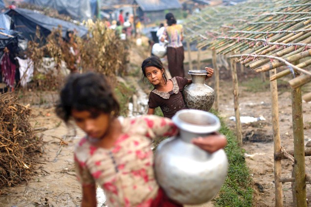 Crianças rohingyas carregam vasos com água em um campo de refugiados, em Bangladesh - 13/09/2017