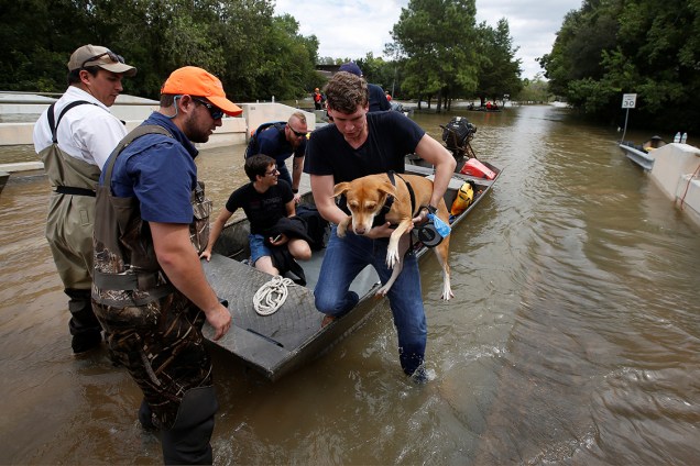Resgate auxilia cachorro e seu dono a evacuarem área alagada por tempestade trazida pelo furacão Harvey, que atingiu estados da costa leste dos Estados Unidos