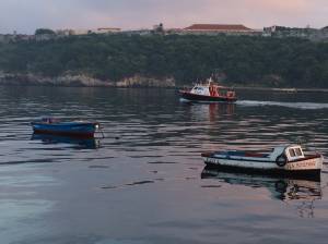 Lancha da polícia vigia pequenos barcos na baía de Havana, em Cuba