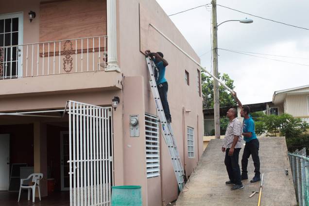 Homens protegem janelas com placas para a chegada do Furacão Irma, em San Juan, Porto Rico