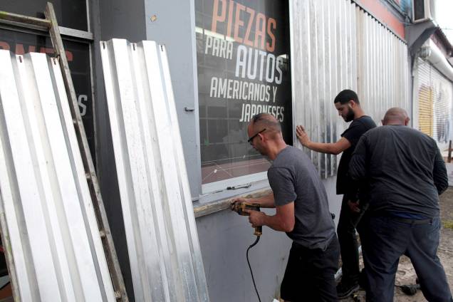 Homens protegem janelas com placas para a chegada do Furacão Irma, em San Juan, Porto Rica