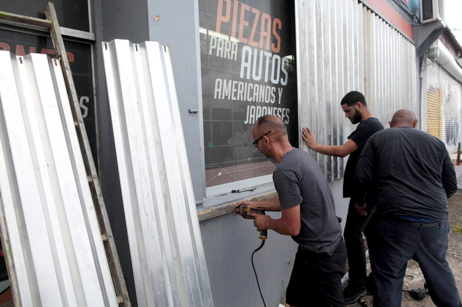 Homens protegem janelas com placas para a chegada do Furacão Irma, em San Juan, Porto Rica
