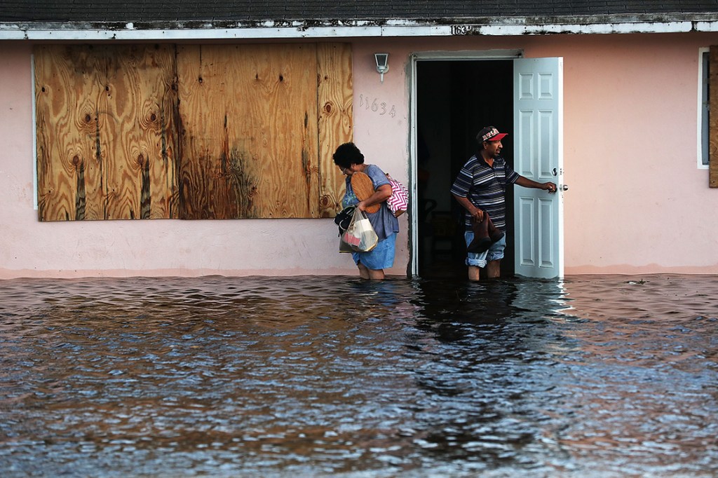 Casal deixa a casa onde moram, em Bonita Springs, na Flórida, após tempestade trazida pelo furacão Irma inundar a região