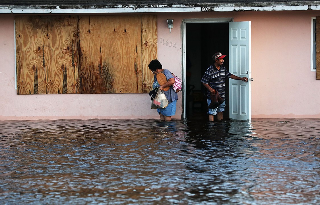 Casal deixa a casa onde moram, em Bonita Springs, na Flórida, após tempestade trazida pelo furacão Irma inundar a região