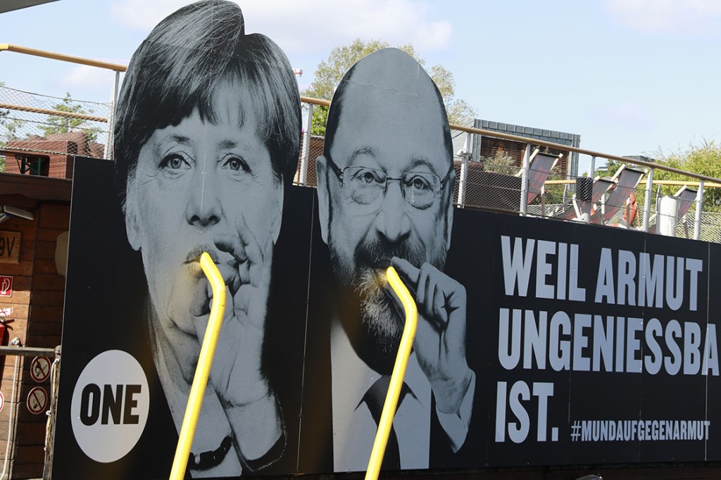 Painel retrata Angela Merkel e seu concorrente, Martin Schulz, com o slogan "Por que pobreza não é comestível", em frente ao rio Spree, em Berlim, na Alemanha